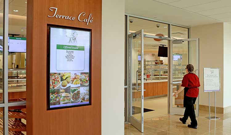 The outside of the Terrace Cafe. There is a screen that shows the menu for the cafe.